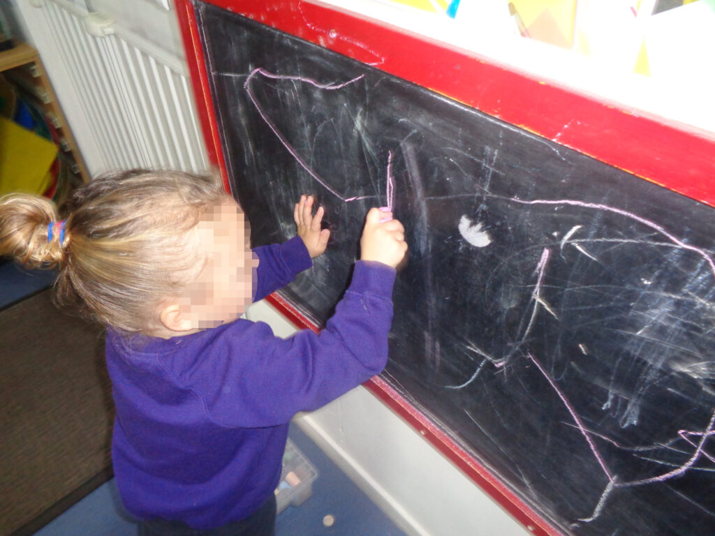Child writing on a chalk board